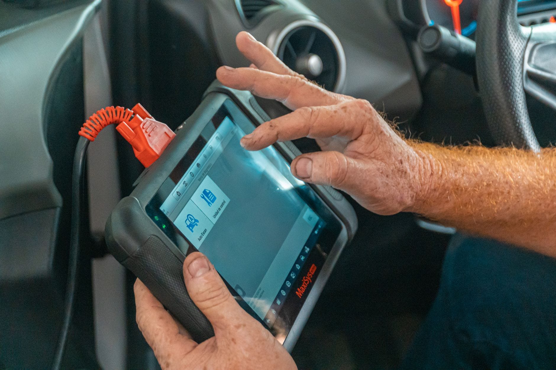 Mechanic using a diagnostic scan tool on a vehicle